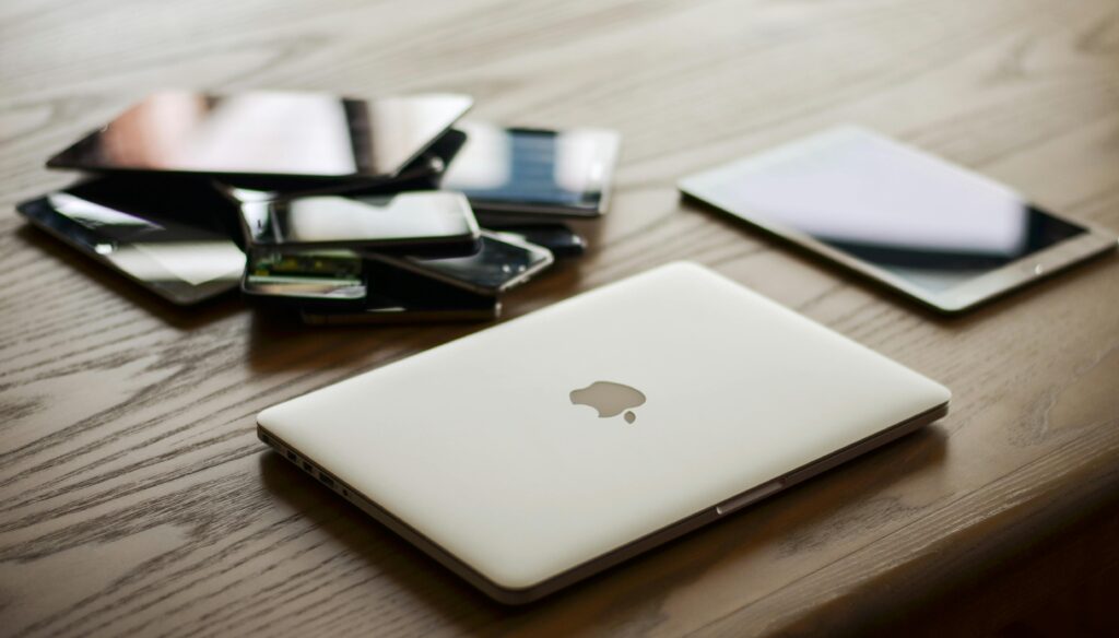 pexels-photo-207589-207589 A variety of modern electronic gadgets, including a laptop and smartphones, on a wooden table.